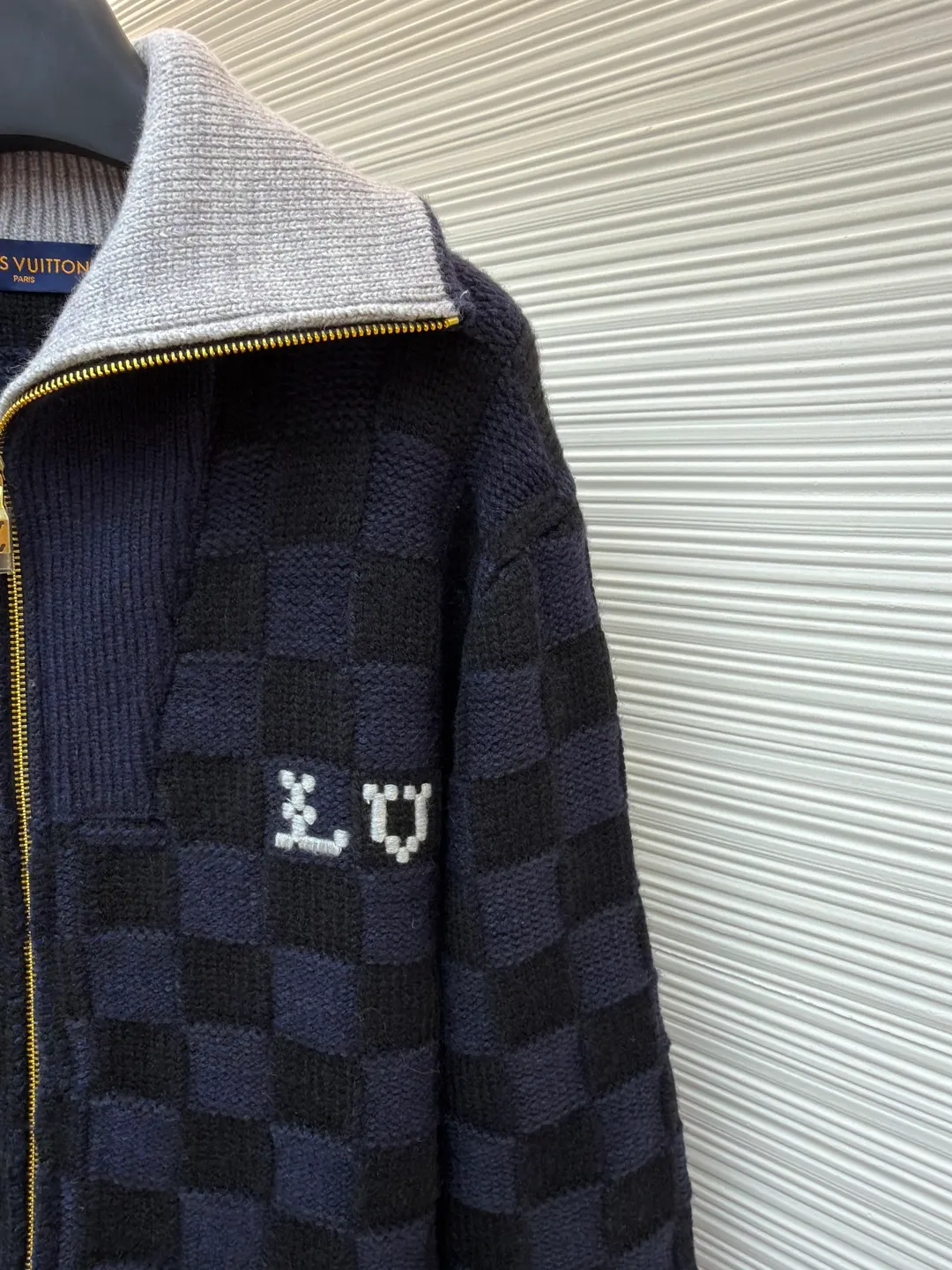 LOUIS VUITTON knitted waist contrast ribbed collar sweater ●Original version: purchased and developed by 20433 ●Item number: 1682136-C10 ●Fabric: wool blended fabric ●Technology: knitted ●Color: black and blue ●Version: fitted version ●Weight: about 1360 grams ●Size: S-M-L-XL ●Description: This Louis Vuitton checkerboard knitted zipper jacket is made of double-ply merino wool blended yarn and is woven with a 12-needle three-dimensional knitting process on a German Stoll computerized flat knitting machine. The Damier checkerboard pattern on the body uses intarsia knitting techniques, and the layered interweaving of dark blue and black yarns creates a 3D concave and convex texture. There is no printed patchwork process, and the pattern and the body are integrated for a more textured look. The neckline is designed with contrasting ribbed lapels, and built-in spandex elastic yarn improves resilience; the metal zipper is made of gold-plated brass, and the teeth are precision polished. The zipper track and the seam of the body are sewn with overlock stitching, and the stitch length is controlled within 0.2cm. The contrasting ribbed edges on the cuffs and hem are pre-shrunk and hand-shaped and ironed, making the garment crisp and less likely to loosen after long-wearing. Every detail demonstrates the brand's strict standards of high-end knitting technology. The overall wiring is straight and delicate, the fabric is comfortable and soft, and the color is consistent without color difference. It can be matched with the same style to create a fashionable look and control various occasions. Customized accessories, complete with three standards, same style for men and women!